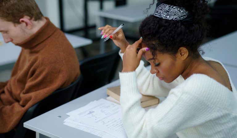 Student preparing for IGCSE exams with books and study materials